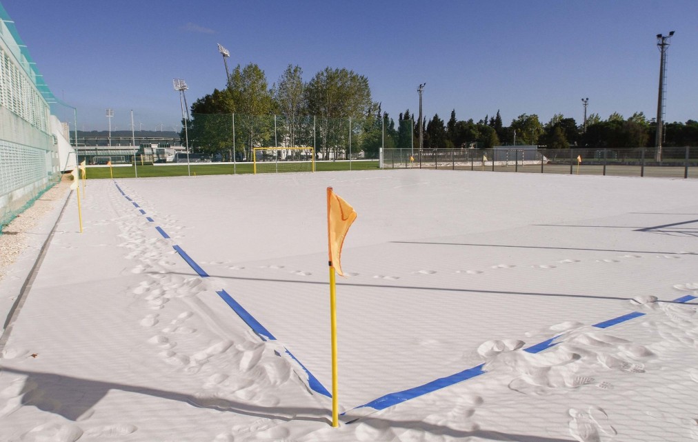 Sandplatz mit Eckfahne und Markierungen für Beach-Soccer-Übungen.