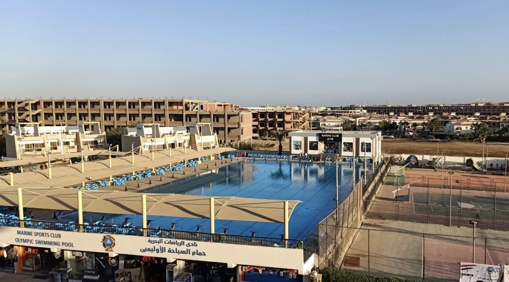 Luftaufnahme des Marine Club Komplexes mit Olympiabecken und Tennisplätzen
