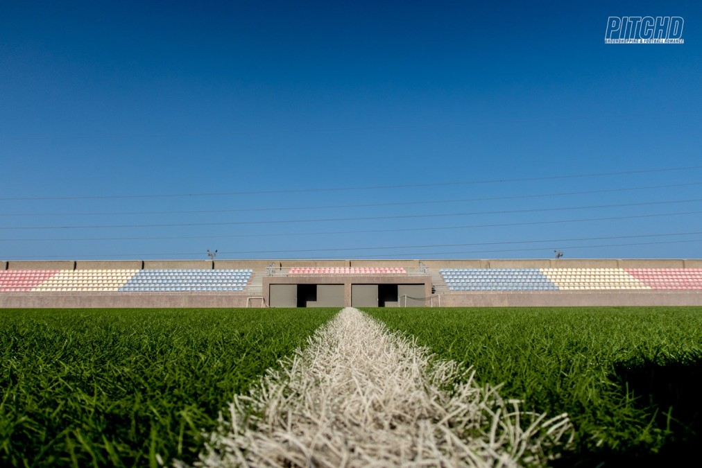 Aufnahme aus der Froschperspektive über das Spielfeld mit Tribünen in mehreren Farben