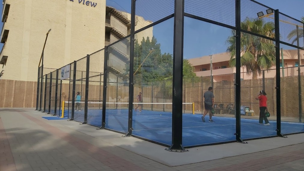 Außen-Padelplatz mit Glaswänden und Personen beim Üben.