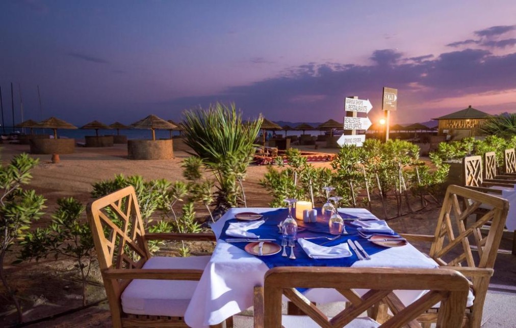Strandnahes Dinner-Setup bei Sonnenuntergang für Team-Abendessen und gemeinsame Zeit.