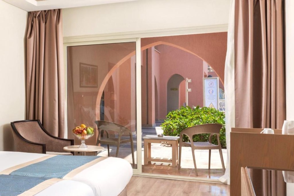 Gästezimmer mit Doppelbett, Obstschale und Terrasse mit Außenstühlen