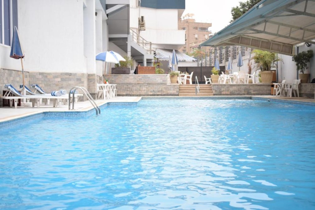 Außenpool mit Sonnenliegen, Sonnenschirmen und Sitzbereich am Pool.