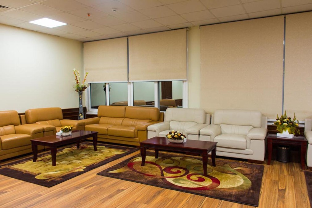 Indoor-Lounge mit Ledersofas, Couchtischen und gemusterten Teppichen.