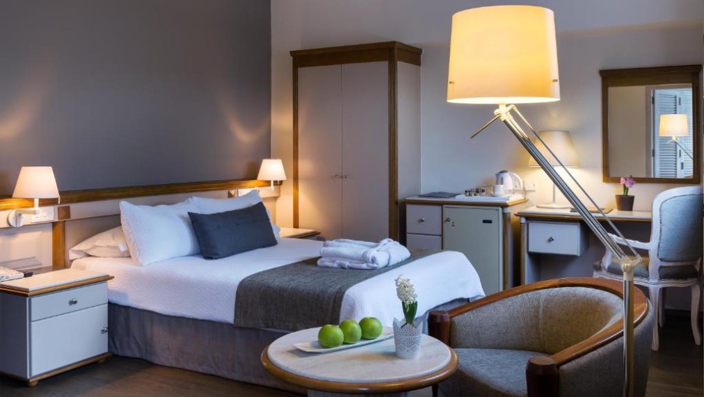 Gästezimmer mit Doppelbett, Schreibtisch, Kleiderschrank und Minibar.