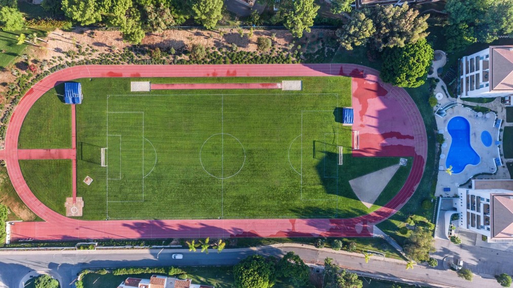 Vue aérienne d'une piste d'athlétisme entourant un terrain de football pleine grandeur.