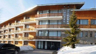 Hôtel alpin avec balcons en bois et neige, hébergement pour athlètes pendant un stage d'entraînement hivernal