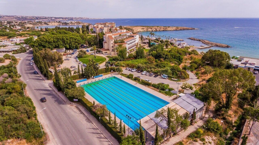 Installation sportive en bord de mer comprenant une grande piscine extérieure et routes adjacentes