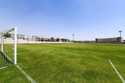 Terrain de football vert avec buts blancs et lignes de délimitation, utilisé pour les séances d'entraînement et les exercices d'équipe