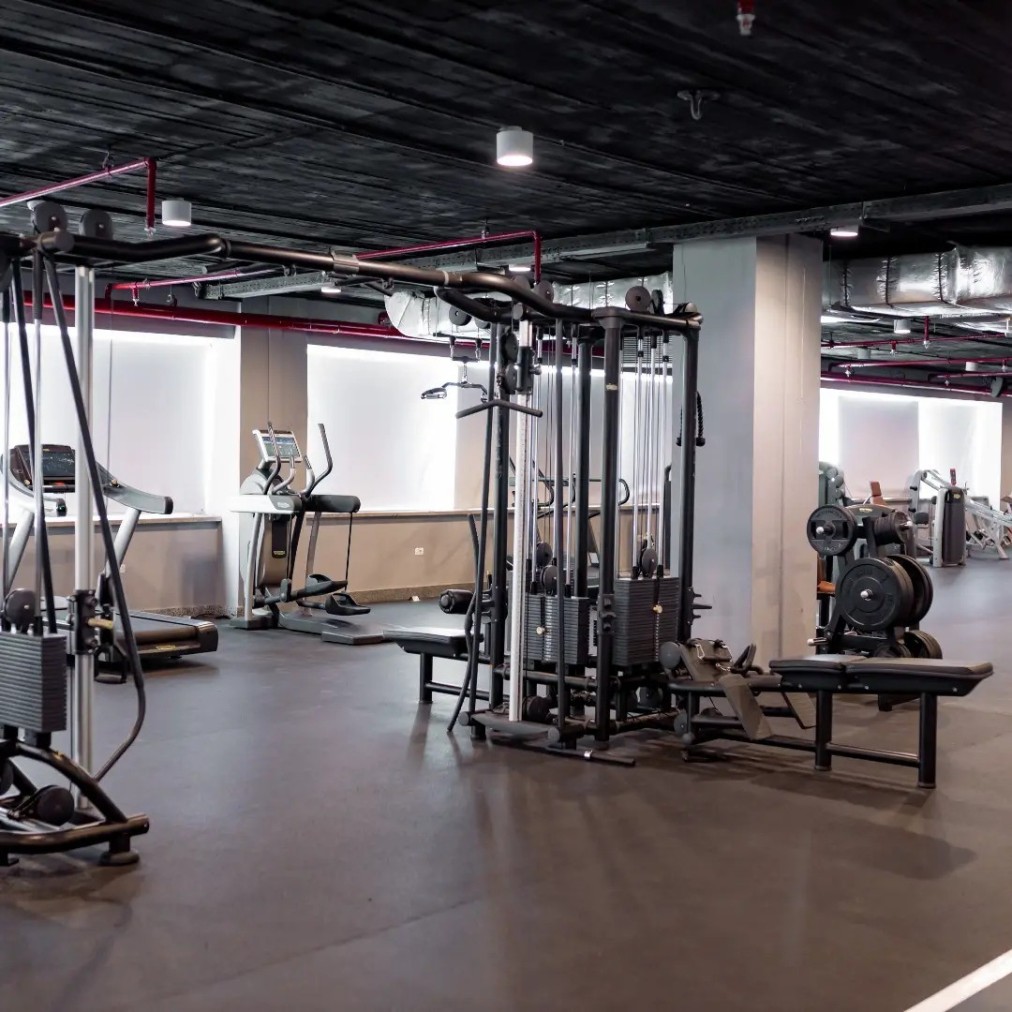 Salle de sport moderne avec appareils de musculation, équipements cardio et espace d'entraînement ouvert