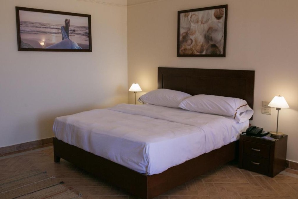 Chambre d'hôtel avec lit double, lampes de chevet et décoration murale pour séjours au calme.