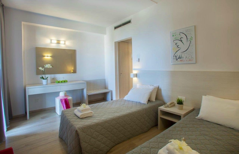 Chambre double lumineuse avec mobilier minimaliste, miroir et plantes décoratives