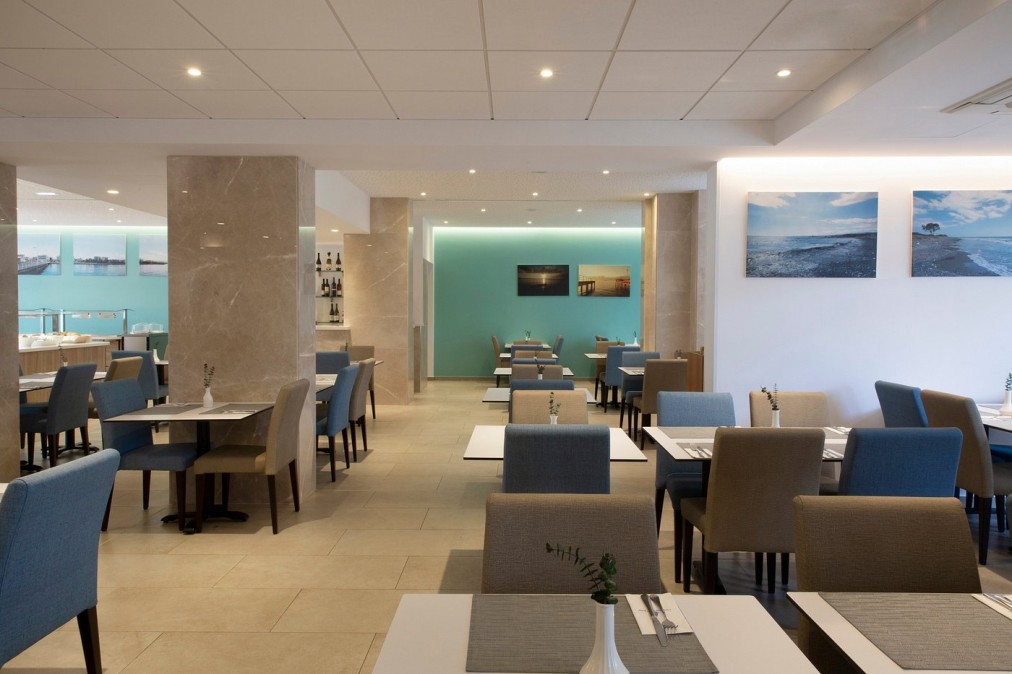 Restaurant moderne avec chaises bleues et beiges et décoration aux tons clairs