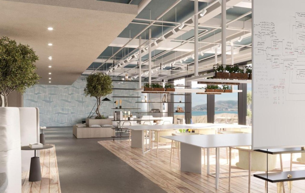 Espace de travail ouvert avec longues tables, verdure et grandes fenêtres