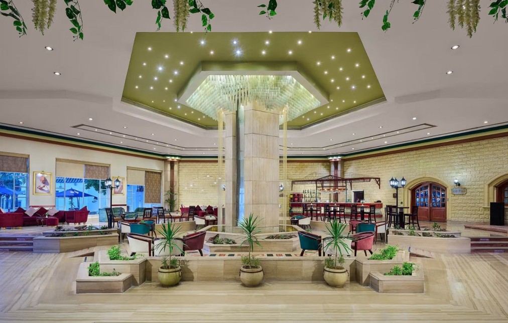 Hall d'hôtel élégant avec fontaine centrale, éclairage moderne et coin salon près d'un bar