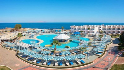 Grand complexe hôtelier en bord de mer avec plusieurs piscines, transats et parasols donnant sur la côte de la mer Rouge
