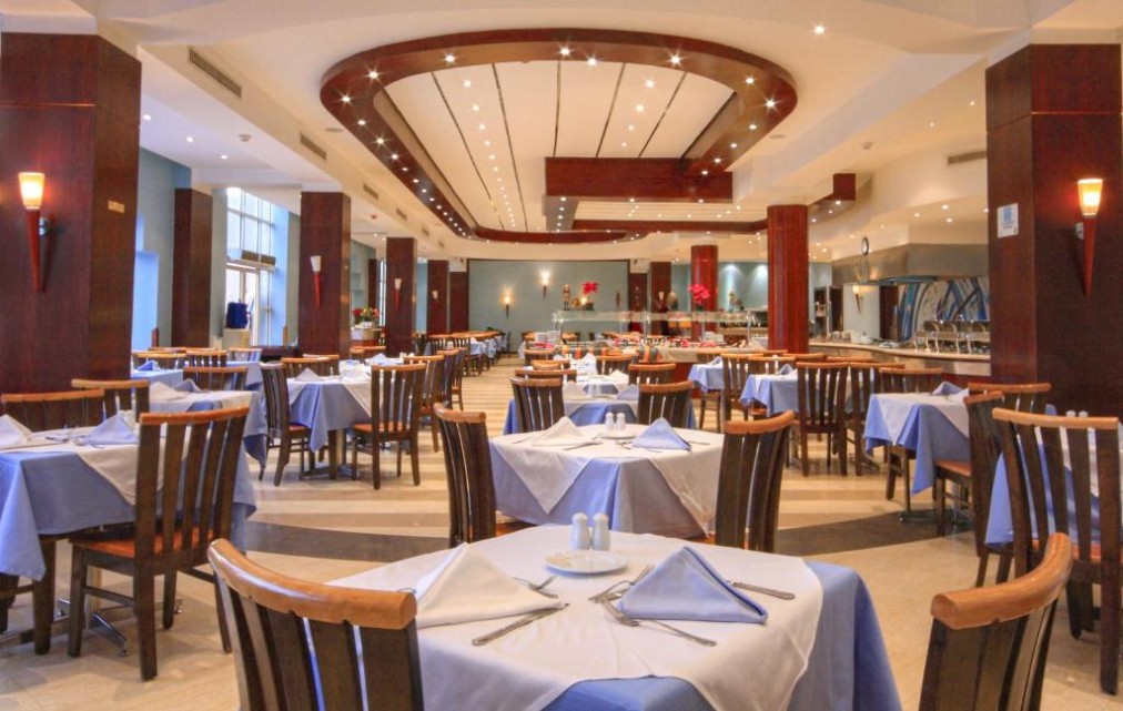Salle à manger spacieuse avec chaises en bois, nappes bleues et éclairage au plafond