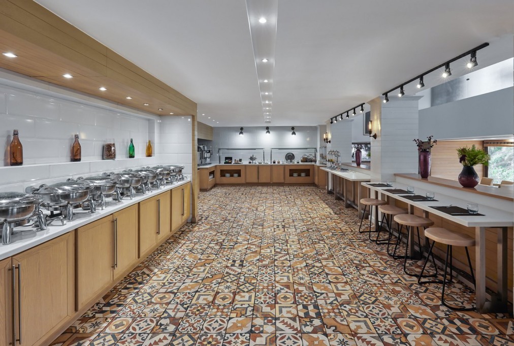 Salle à manger buffet avec chauffe-plats, sol en carreaux à motifs et sièges de bar pour repas de stage d'entraînement
