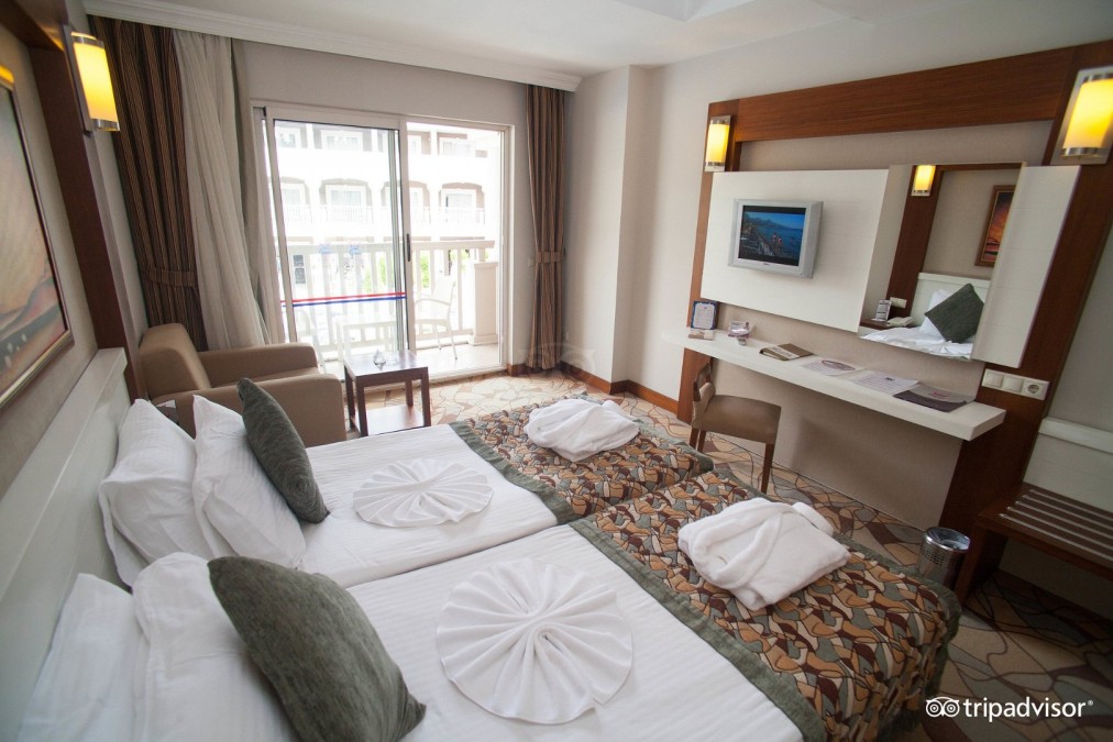 Chambre twin avec balcon, bureau, TV et coin salon pour hébergement de stage sportif.