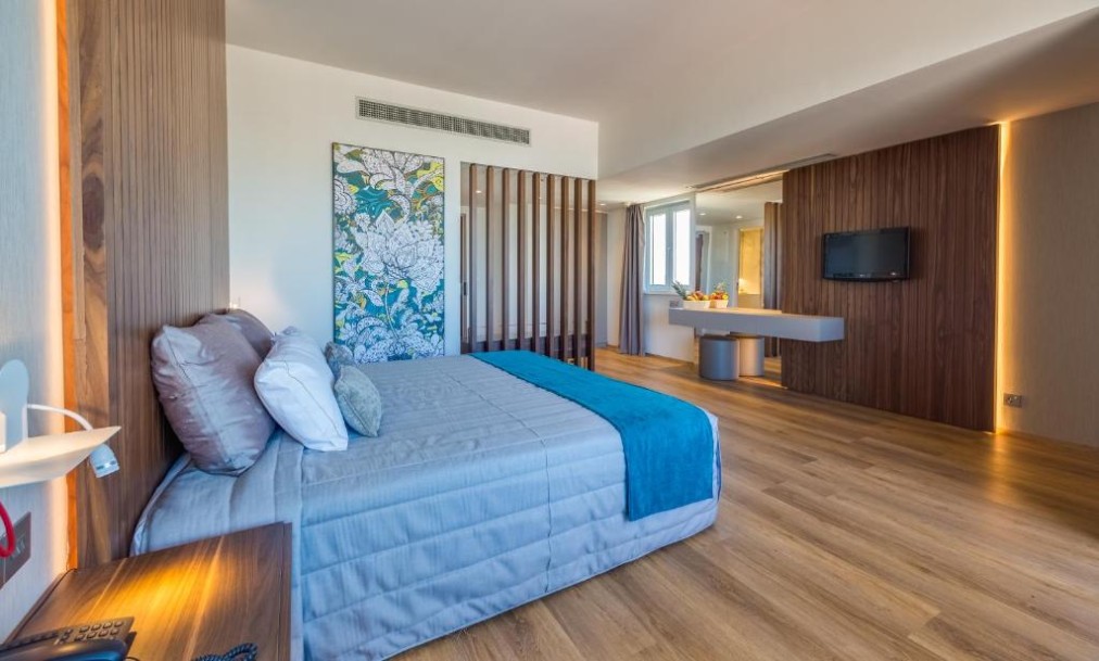 Chambre spacieuse avec lit double, bureau et murs lambrissés.